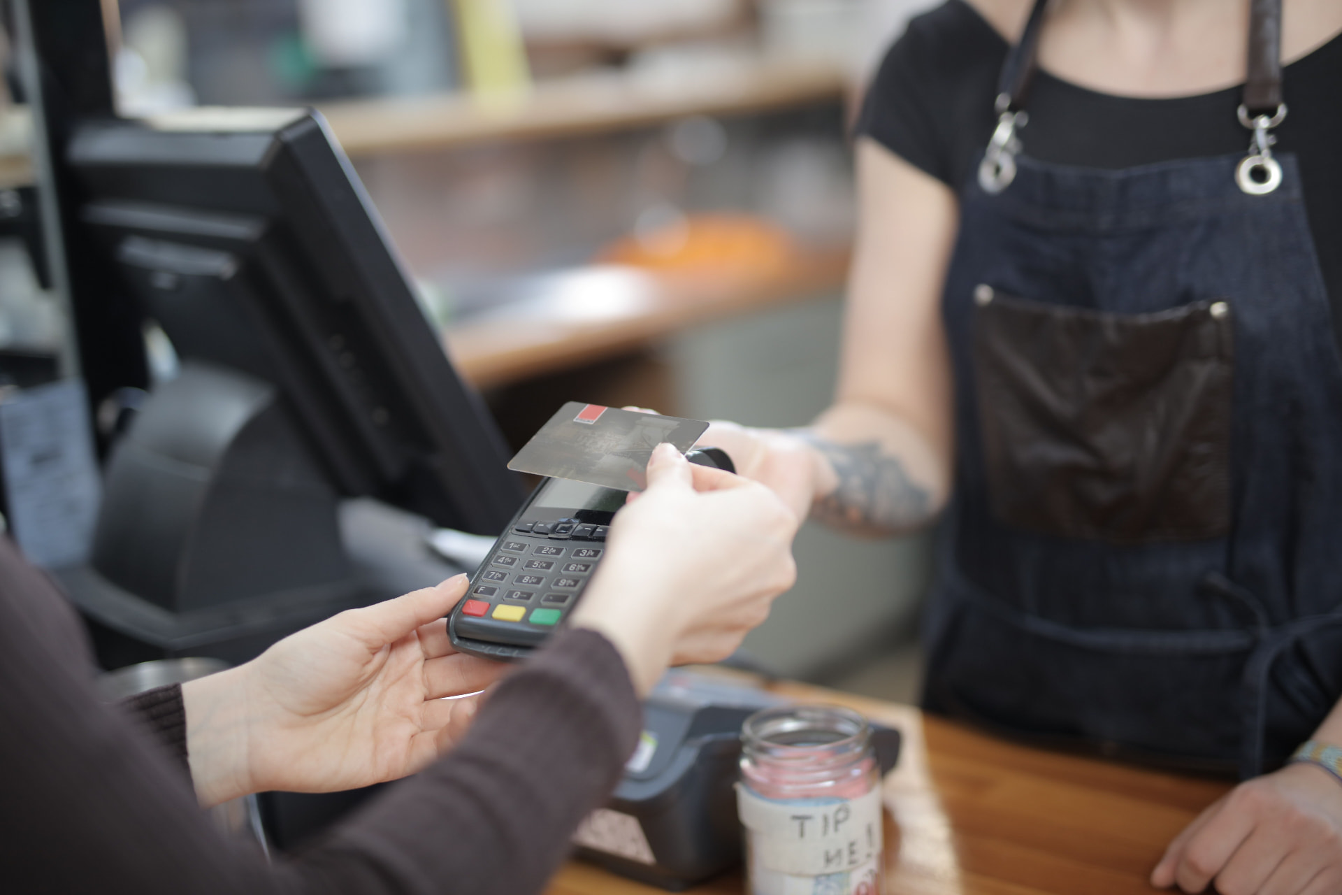 Cliente pagando con tarjeta en el datáfono de un comercio